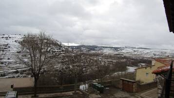A view of a snow-covered landscape with a building in the foreground.