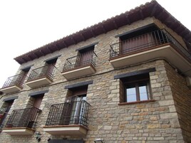 Un edificio de piedra de varios pisos con balcones y ventanas.