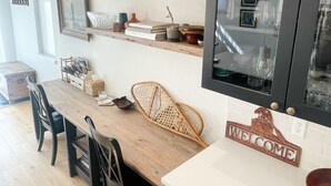 Eine Küche mit Holzregalen, einem Esstisch, Stühlen und einem Willkommensschild.