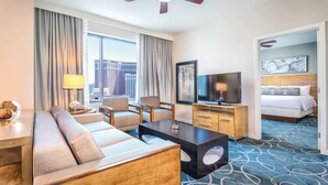 A hotel room with a sofa, armchairs, a TV, a desk, and a bed. - 3BD/Vegas - Full Kitchen, Washer/Dryer, and Private Living Room! (Las Vegas)