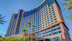 A high-rise hotel with a curved facade, multiple floors, and a mix of glass and concrete exterior. - Vegas Studio - Pools, Hot Tubs, and Shuttle to the Strip! (Las Vegas)