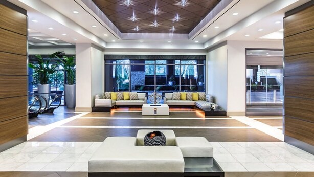 A modern lobby with a seating area, large windows, and a wooden ceiling. - 1BD/Vegas - Pool, Hot Tub, and Shuttle to the Strip! (Las Vegas)