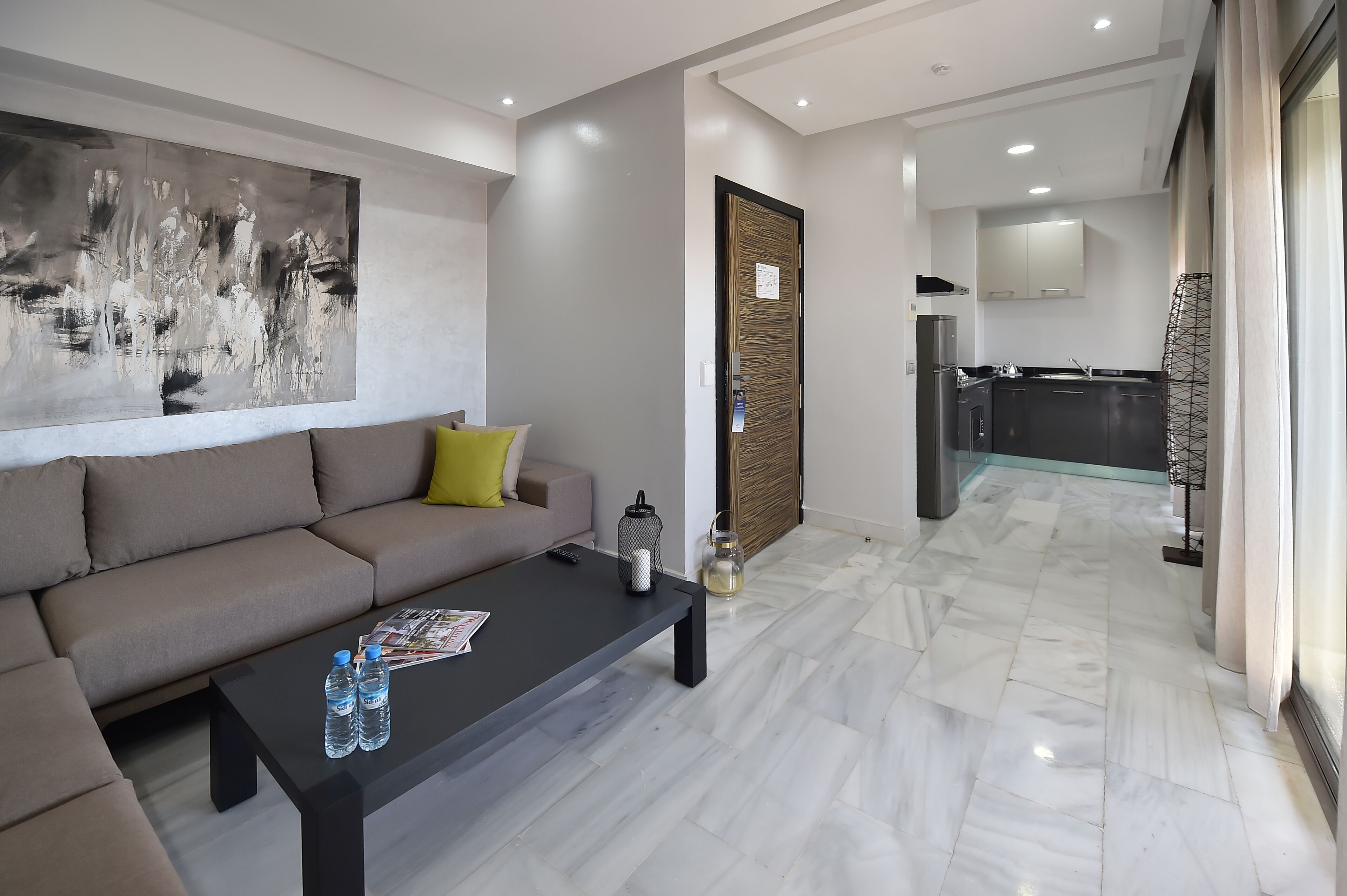 Een moderne woonkamer met een bank, salontafel en kunstwerk.