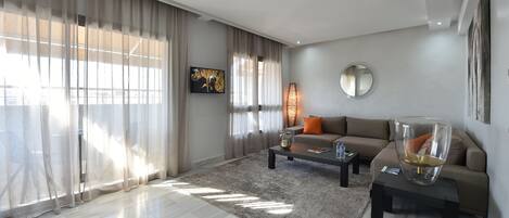 Una sala moderna con sofá, mesa de centro y lámpara decorativa.
