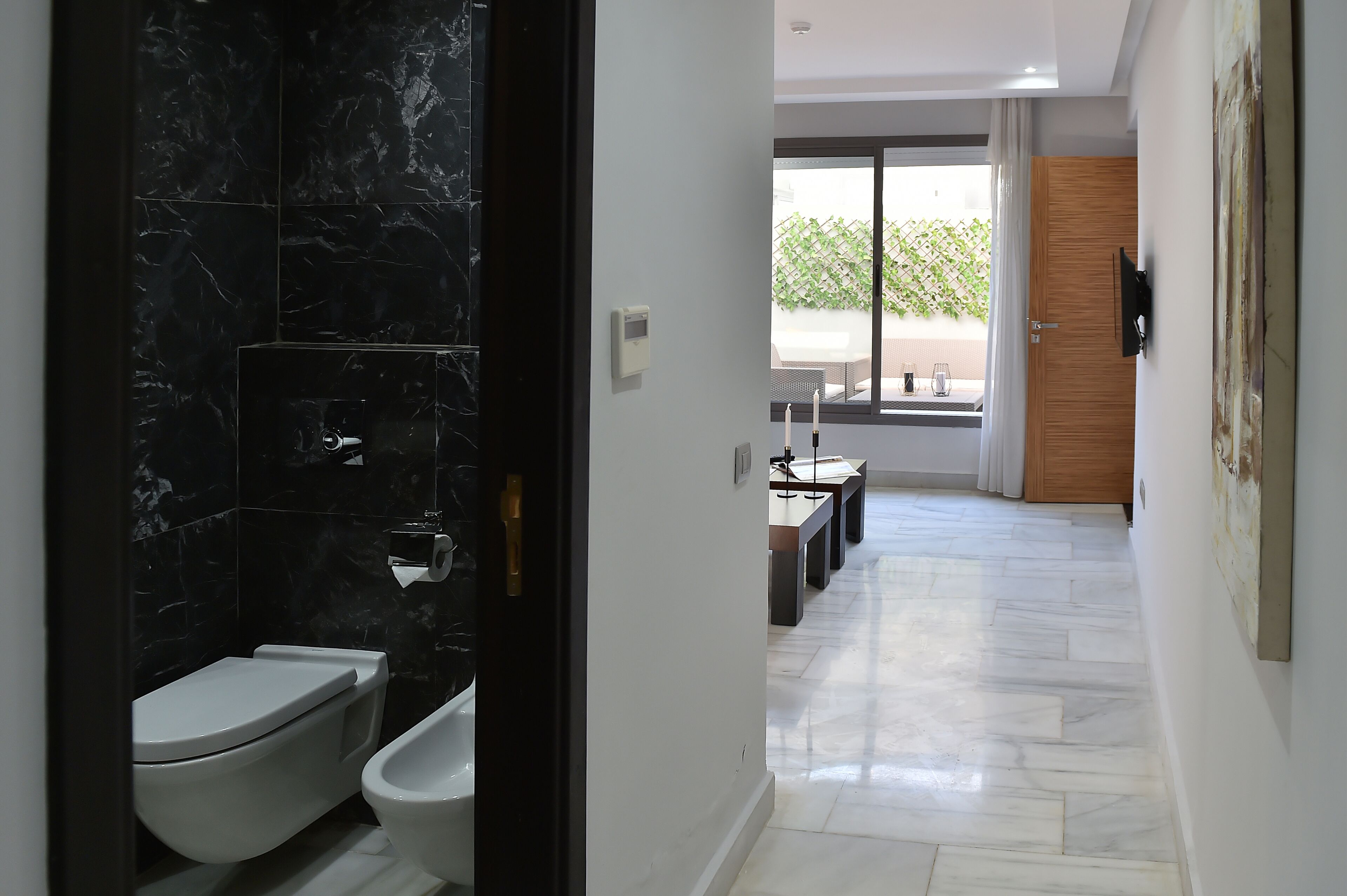 A modern bathroom with a toilet, bidet, and a shower area.