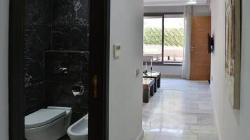 A modern bathroom with a toilet, bidet, and a shower area.