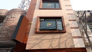 A multi-story building with two visible windows, each with a decorative wreath. - OYO 27650 Gian Residency (Amritsar)