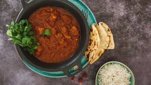 A bowl of curry with naan bread and a bowl of rice on a table. - OYO 27650 Gian Residency (Amritsar)