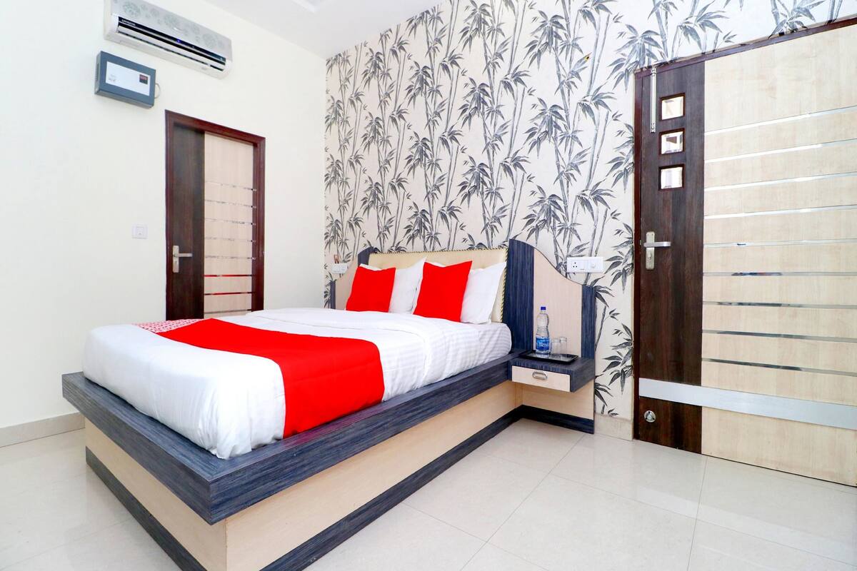 A modern bedroom with a bed, bedside table, and wardrobe.