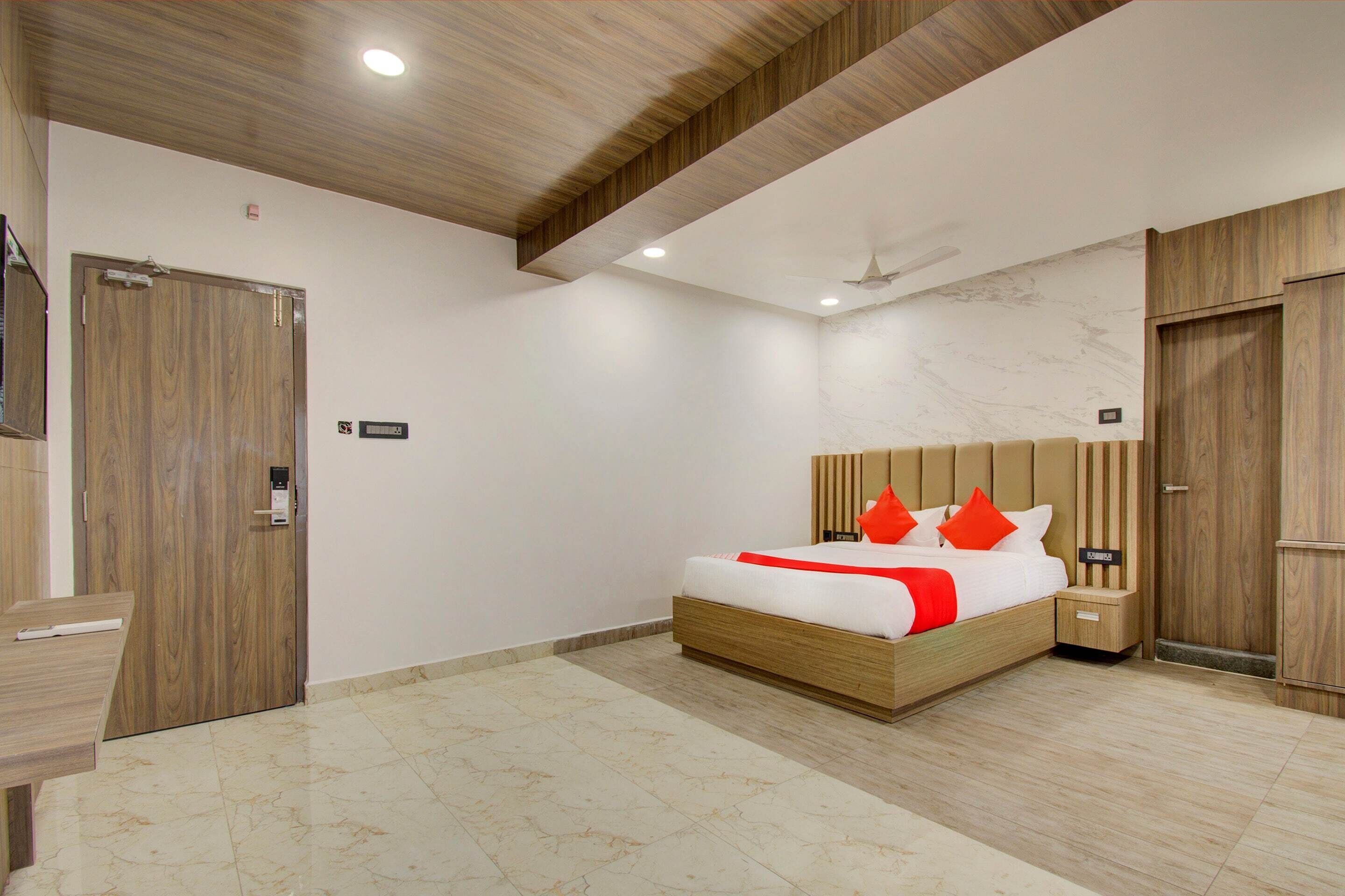 Quarto moderno com cama de madeira, mesa de cabeceira, guarda-roupa de madeira e banheiro com porta de madeira.