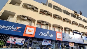 A multi-story building with balconies, air conditioning units, and storefronts for brands like Xiaomi and Samsung. - OYO 29087 Hotel Golden Pride (Hyderabad)