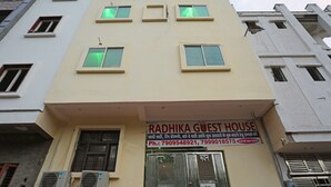 Un bâtiment sur lequel on peut lire l’inscription « Radhika Guest House » et qui est équipé de plusieurs unités de climatisation.