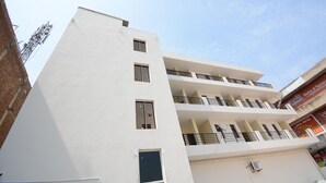 A multi-story building with balconies and a brick facade. - OYO 37658 King Palace (Mohali)