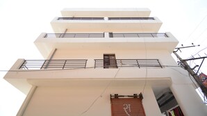 A multi-story building with balconies and a window with a shutter. - OYO 37658 King Palace (Mohali)