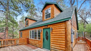 A log cabin with a green door, a deck, and a small porch. - Nine Pines Lodge#537 (Big Bear City)