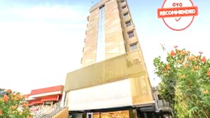 Ein mehrstöckiges Hotel mit modernem Design, das eine markante Eingangspforte und eine gut sichtbare Treppe zu den oberen Stockwerken aufweist.