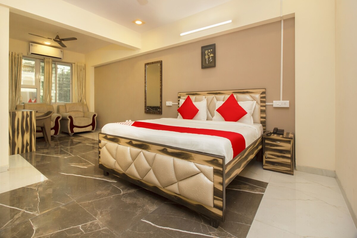 A modern hotel room with a large bed, a desk, and a chair.
