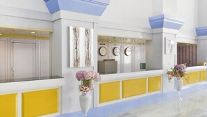 A reception area with a marble floor, a reception desk, and two vases with flowers. - Capital O 44162 Royal Palms Hotel - Rose Collection (Mumbai)