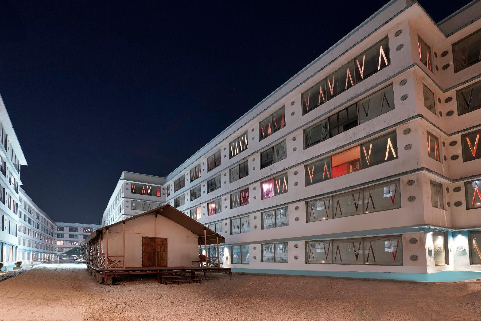 A multi-story hotel with a distinctive architectural design, featuring a series of balconies and large windows.