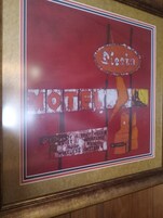 Letrero antiguo de motel con el nombre 'Motel Fiesta' y la indicación de 'dieciséis habitaciones' y 'internet inalámbrico'.