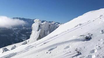 A snow-covered mountain slope with a clear sky.