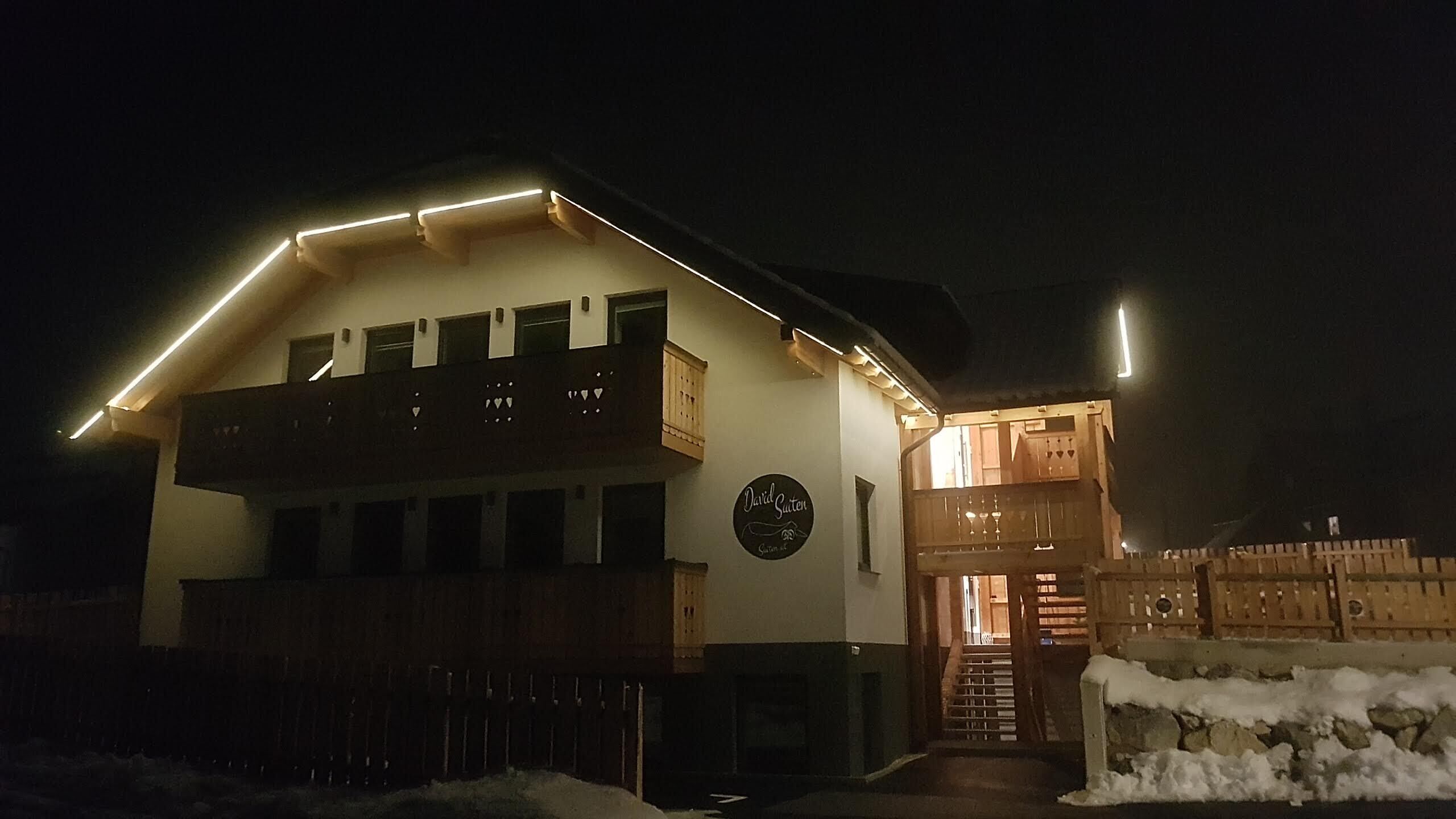 A two-story building with a balcony and a wooden fence in front.