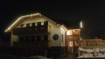 A two-story building with a balcony and a wooden fence in front.