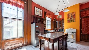 A kitchen with wooden cabinets, a stainless steel refrigerator, a stove, and a microwave.