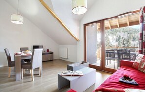 A modern, well-lit room with a dining area, a sofa, and a large sliding glass door leading to an outdoor patio. - Swimming pool, parking, tv, ski locker, 37-46m², Serre Chevalier (SERRE CHEVALIER)