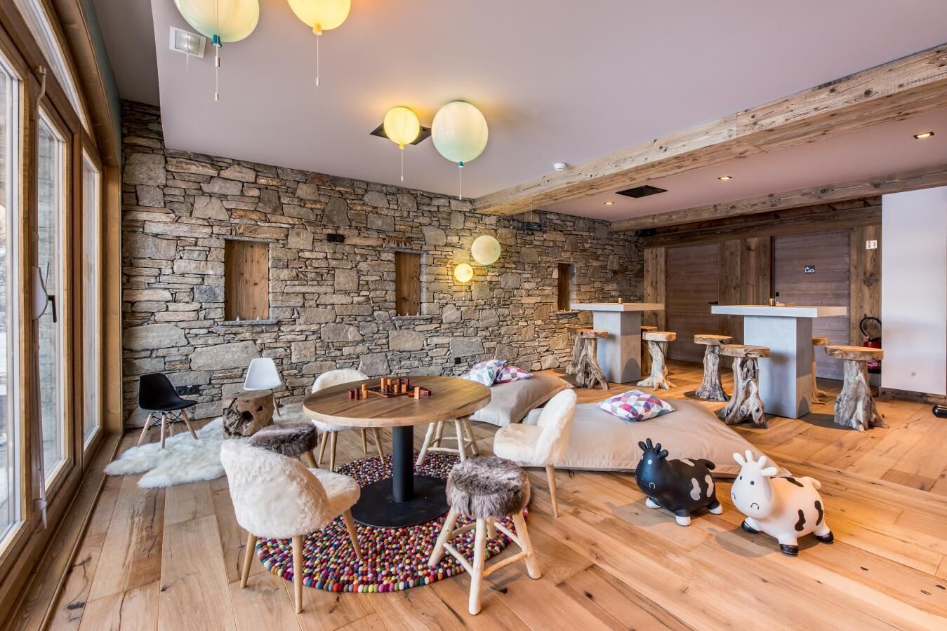 Une pièce chaleureuse avec un mur en pierre, des meubles en bois et une table ronde.