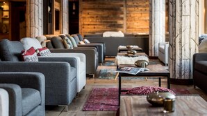 A modern living room with grey sofas, a coffee table, and a fireplace.