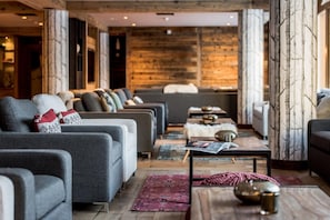 A modern living room with grey sofas, a coffee table, and a fireplace.
