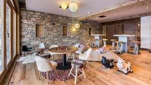 A cozy room with a stone wall, wooden furniture, and a round table.