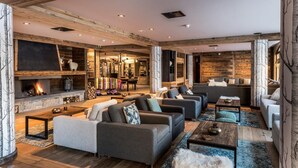 A spacious living room with a fireplace, sofas, and a dining area.