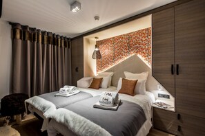 Quarto moderno com uma cama grande, guarda-roupa embutido e um painel decorativo na parede.