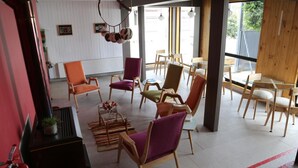 A modern interior with wooden furniture, a fire extinguisher, and a potted plant. - Hotel Ilaia (Punta Arenas)