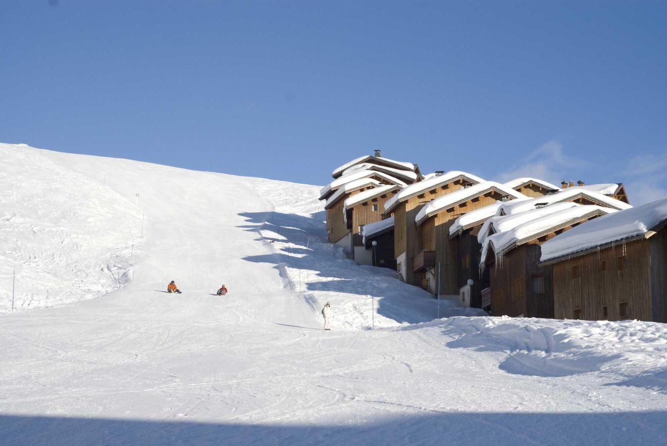 Ein mit Schnee bedeckter Skipisten mit Holzchalets.