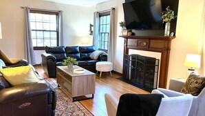 A living room with a fireplace, a television, and a sofa. - Hot Tub | Sauna | 1.1 MI to ND  | Backyard Oasis (South Bend)