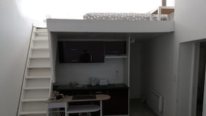 A compact kitchenette with a small dining area, a built-in stove, and a microwave. - Charming Duplex 4 people (FLEURY-SUR-ORNE)