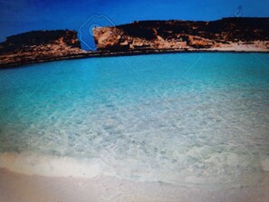 Ein Küstenblick mit blauem Meer und steiniger Küstenlinie.