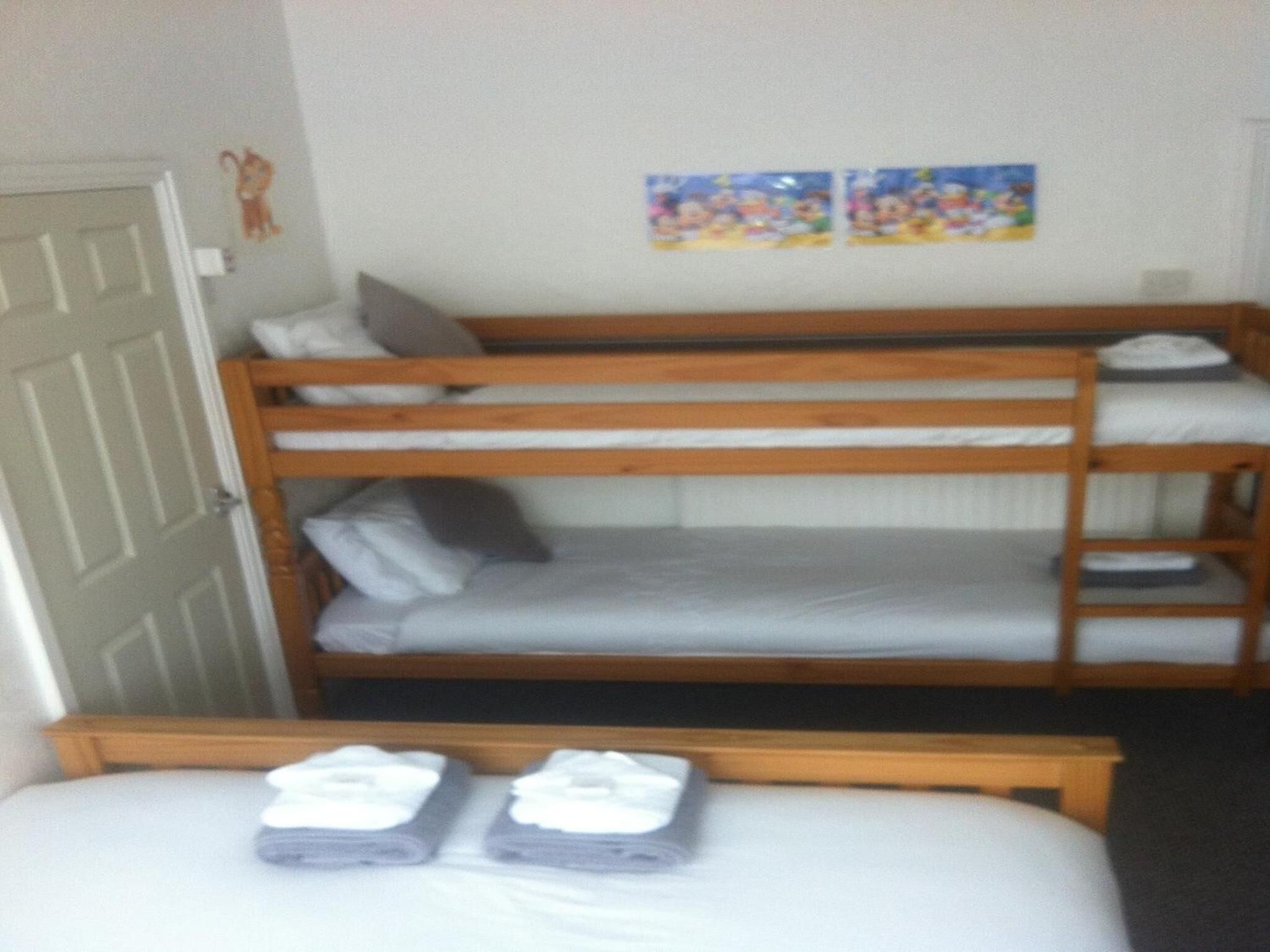 A room with two bunk beds, a single bed, and a door.