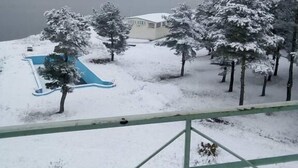 A snowy landscape with a building, trees, and a blue slide. - Hotel Tsalka (Tsalka)