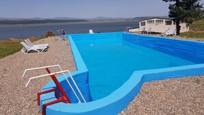 A swimming pool with a view of the water body and hills in the background. - Hotel Tsalka (Tsalka)