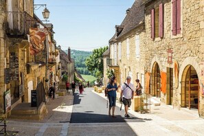 A narrow street lined with stone buildings, some with shops and cafes. - Beautiful Le Coutal - Private Pool - Dordogne (Berbiguières)