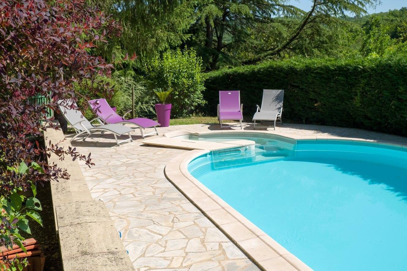 Een buitenzwembad en ligstoelen