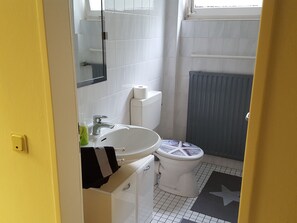 A bathroom with a white sink, toilet, and mirror. There is a towel hanging on the wall and a shower curtain. - 4 Jahreszeiten (Lauenau)