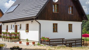 A wooden house with a sloped roof, white walls, and multiple windows. - Imperial house (Plitvicka Jezera)