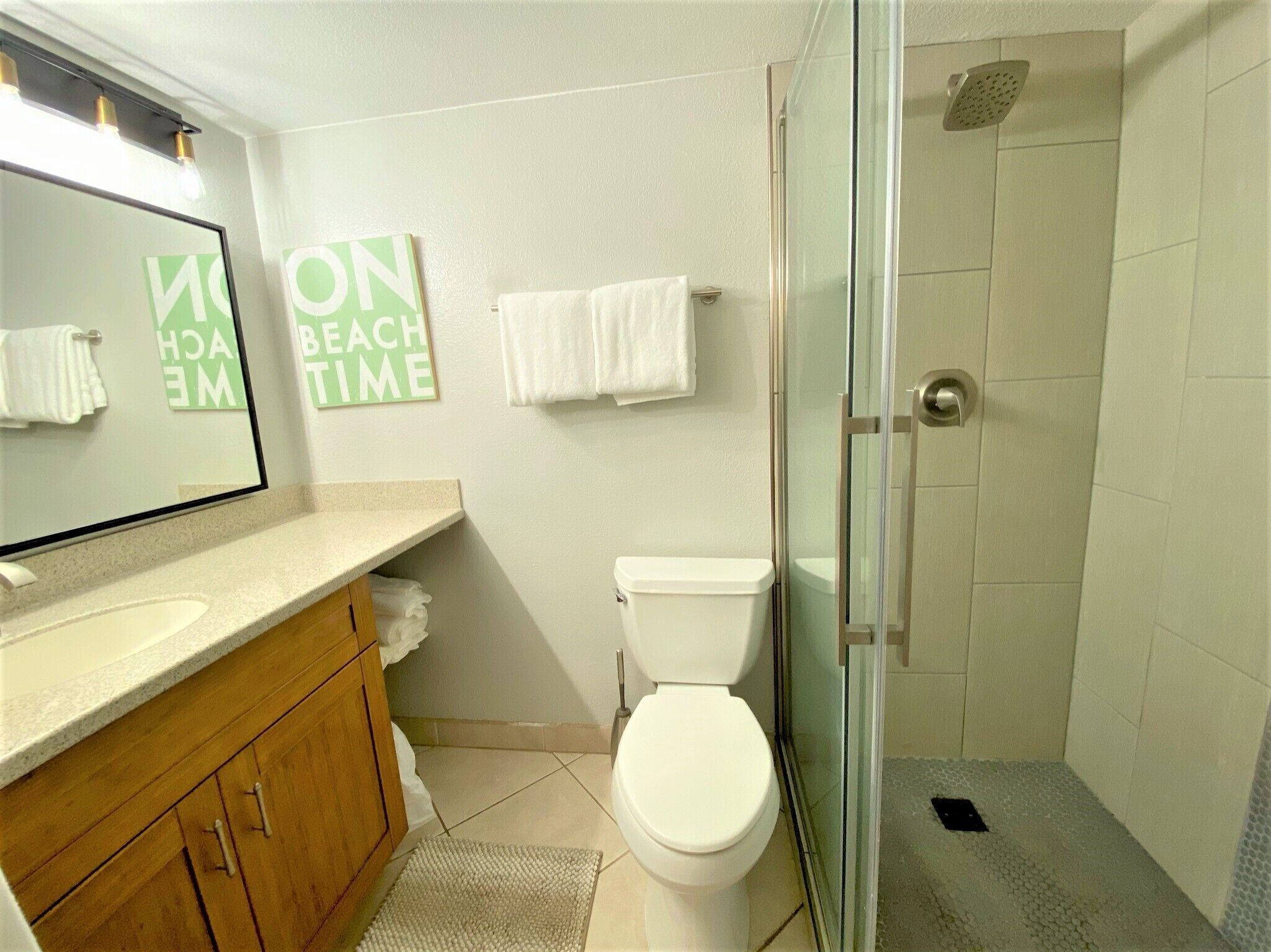 Een badkamer met toilet, wastafel, douche en spiegel.