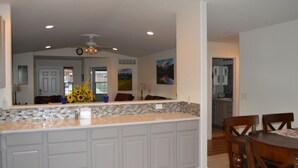 A spacious kitchen with a large island, white cabinetry, and a tiled backsplash. - Colorado Getaway w/ Hot Tub & Fire-pit Sleeps 16+ (Northglenn)