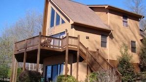 Une maison en bois à deux étages, dotée d’un balcon et d’un porche couvert.